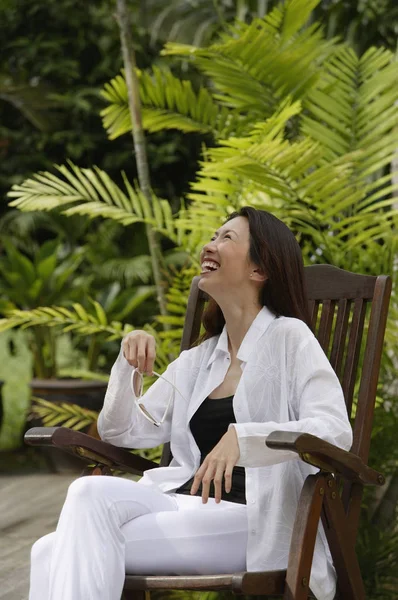 Vrouw zitten in de groene tuin — Stockfoto