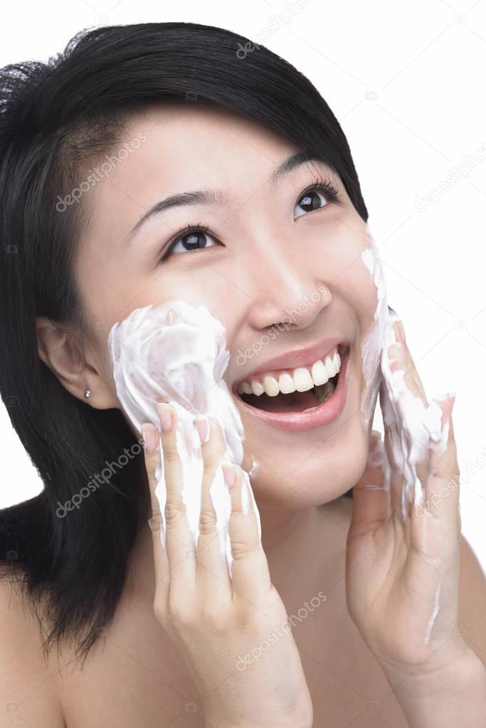 woman putting facial cleanser