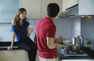 Adam mutfakta yemek pişiriyor.
