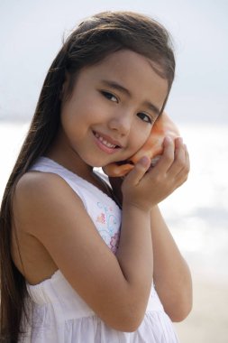 girl holding giant conk shell clipart
