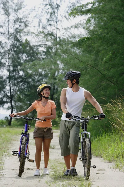 Coppia a piedi con biciclette — Foto Stock