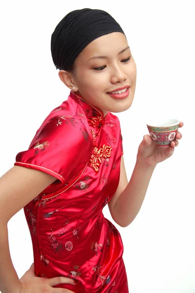 Woman in cheongsam with cup of tea — Stock Photo, Image