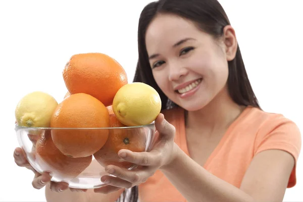 Vrouw bedrijf kom van sinaasappelen — Stockfoto