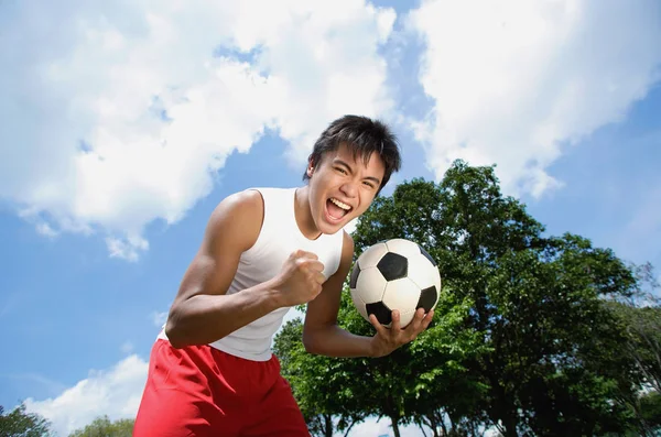 Человек держит футбольный мяч — стоковое фото