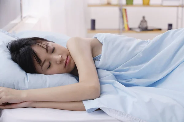 Joven mujer durmiendo en la cama —  Fotos de Stock