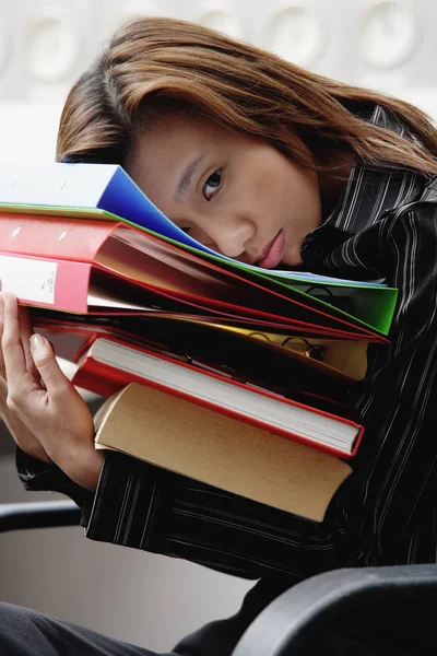 Femme penchée sur une pile de liants — Photo