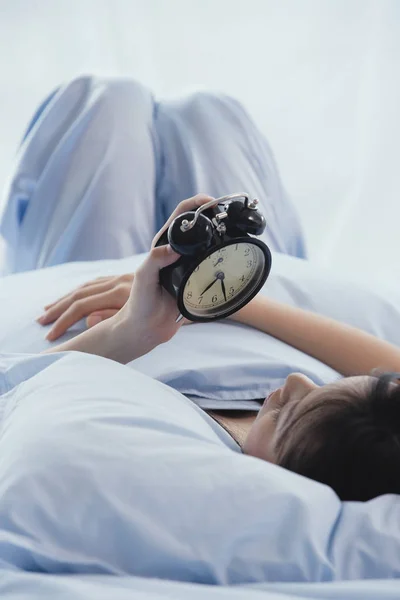 Womanlooking at alarm clock — Stock Photo, Image