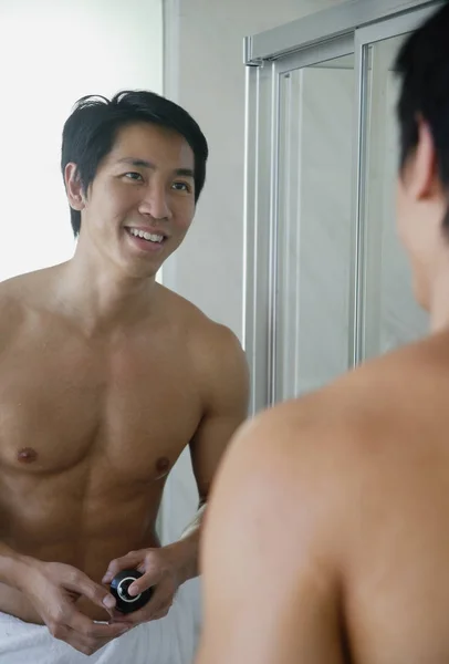 Hombre en el baño, mirando al espejo — Foto de Stock