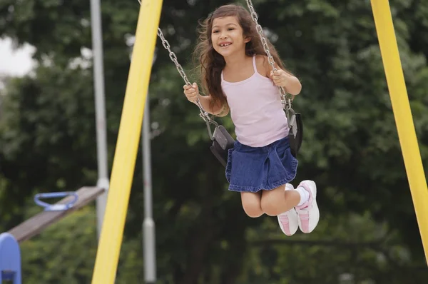 Menina no parque infantil swing — Fotografia de Stock