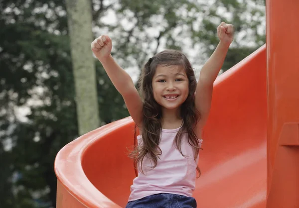 Menina descendo playground — Fotografia de Stock