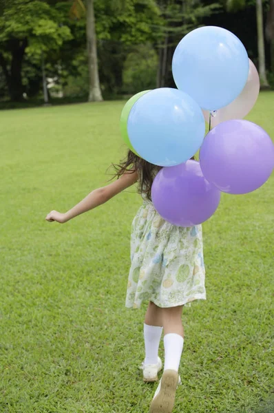 Flicka som håller ballonger — Stockfoto