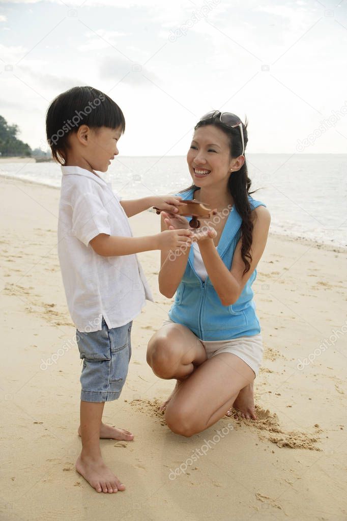 boy outside on beach with mother