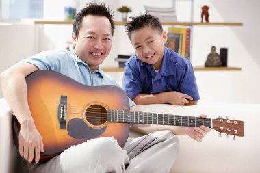 Baba oğul gitar çalıyor.