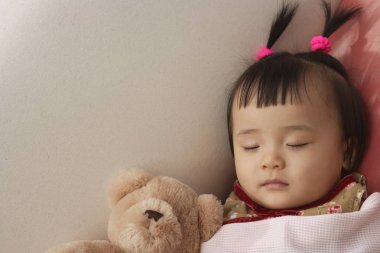 baby girl sleeping with teddy bear 