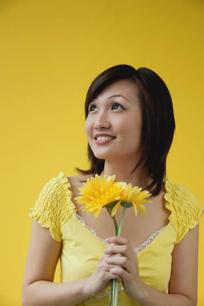 Mujer sosteniendo flores amarillas — Foto de Stock