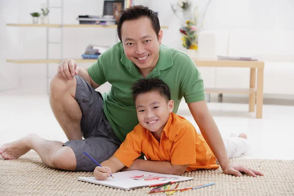 Pai e filho desenhando em caderno de esboços — Fotografia de Stock