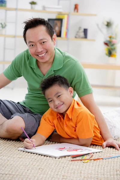 Pai e filho desenhando em caderno de esboços — Fotografia de Stock