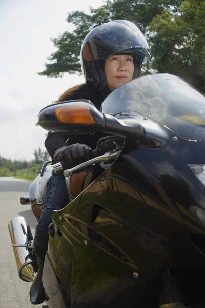 Зрелая женщина с мотоциклом — стоковое фото