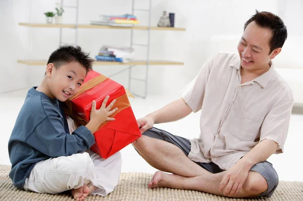 Батько і син відкривають подарунок — стокове фото