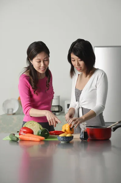 Mother and adult daughter in kitchen — Stock Photo, Image