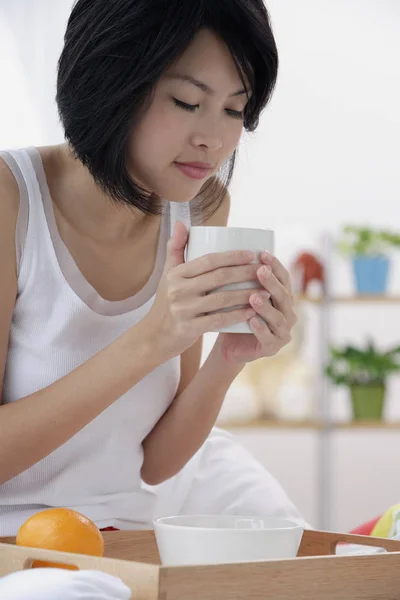 朝食をとる若い女性は — ストック写真