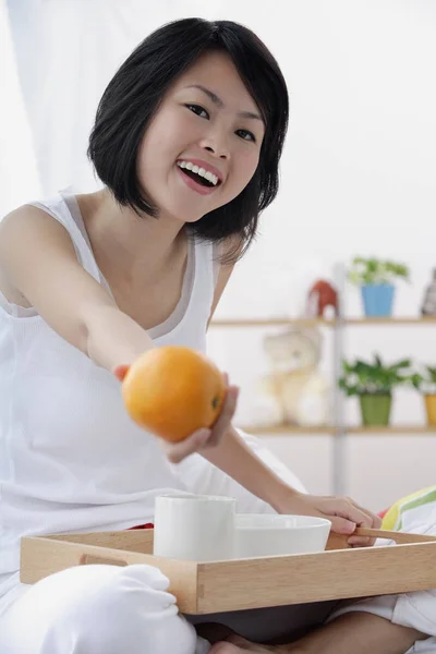 오렌지를 들고 있는 젊은 여자 — 스톡 사진