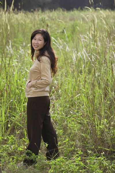 Kvinna stående i högt gräs — Stockfoto