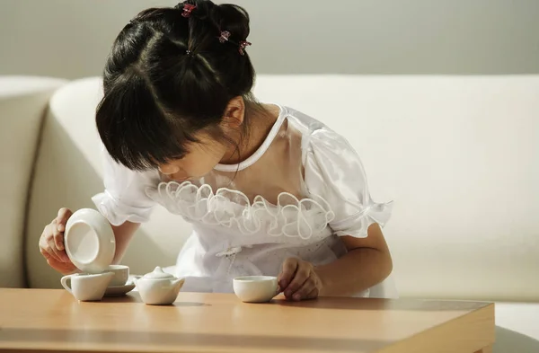 Girl playing with tea cups — Stock Photo, Image