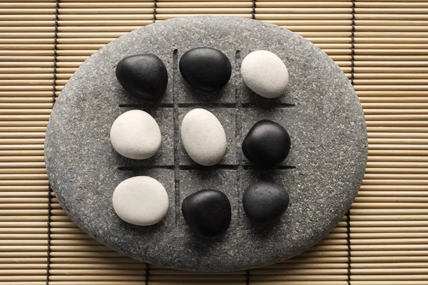 Guijarros blancos y negros sobre piedras zen — Foto de Stock