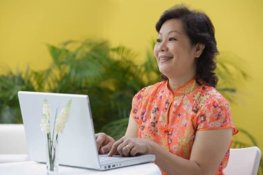 Laptop kullanan olgun bir kadın