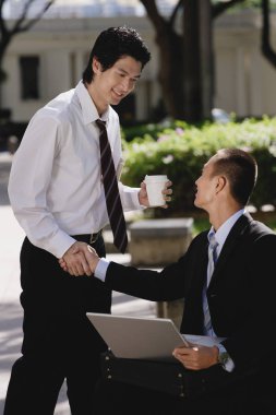 Two men greet each other and shake hands  clipart