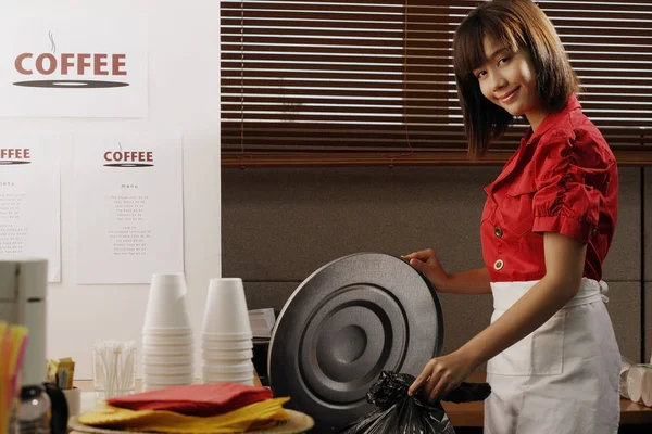 Waitress in diner taking out trash — Stock Photo, Image