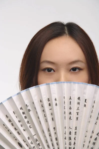 woman with fan looking at camera