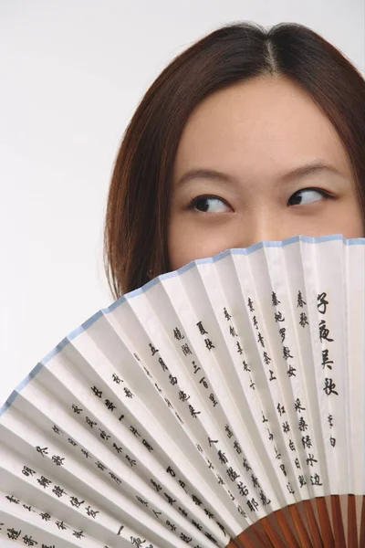 woman with fan looking sideways