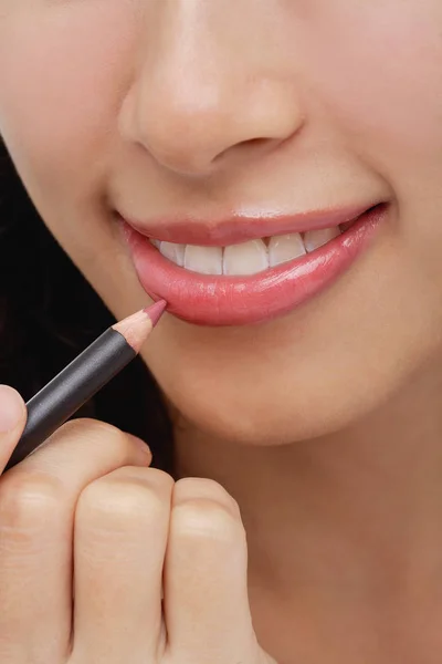 Wanita menerapkan pensil bibir — Stok Foto