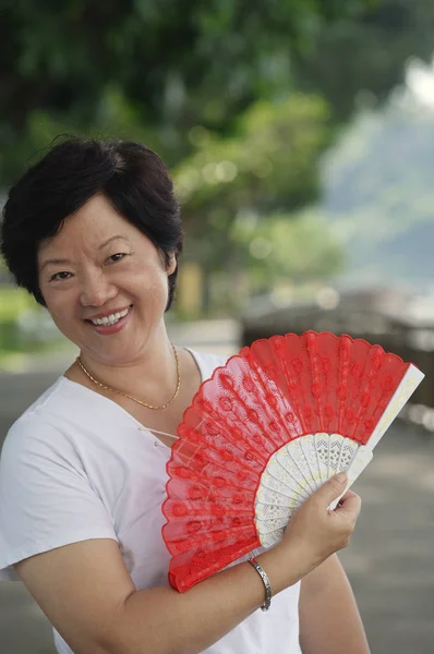 Woman with fan smiling