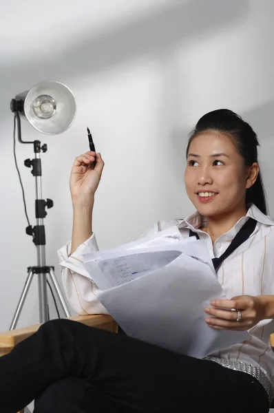 Женщина сидит с бумагой и ручкой — стоковое фото