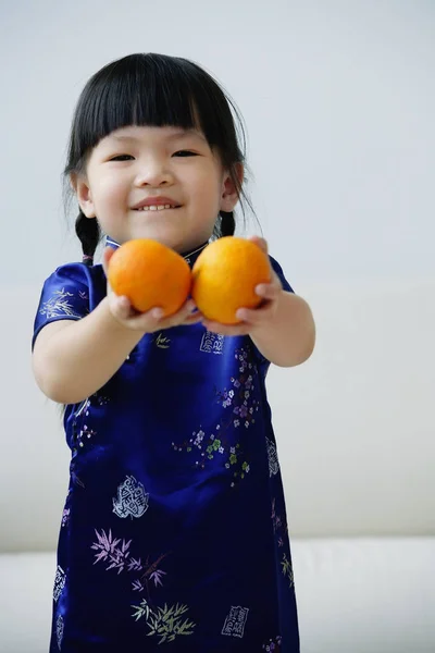 Ragazza tiene fuori due mandarini — Foto Stock