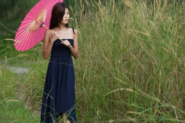 Женщина в траве с зонтиком — стоковое фото