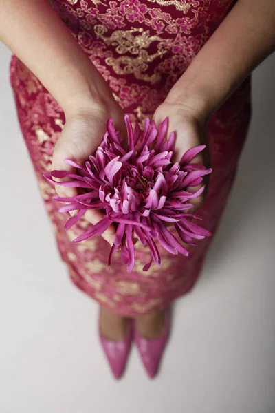 Purple flowers in hands — Stock Photo, Image