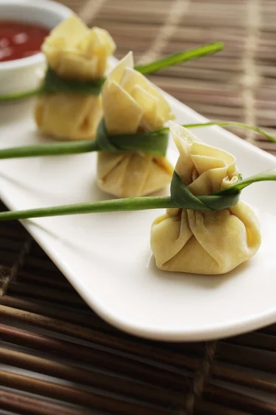 3 baldadig dumplings in een rij op een witte plaat geplaatst — Stockfoto