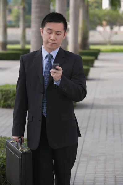 Obchodník držící mobilní telefon — Stock fotografie