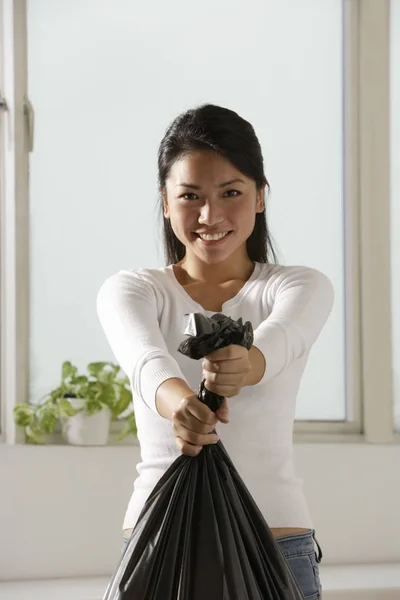 woman holding trash bag