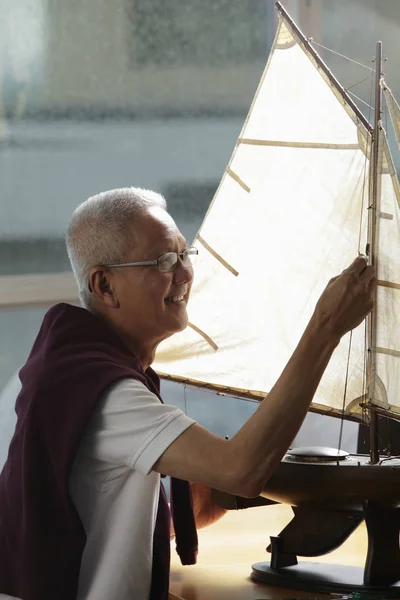 Hombre maduro trabajando en barco modelo — Foto de Stock
