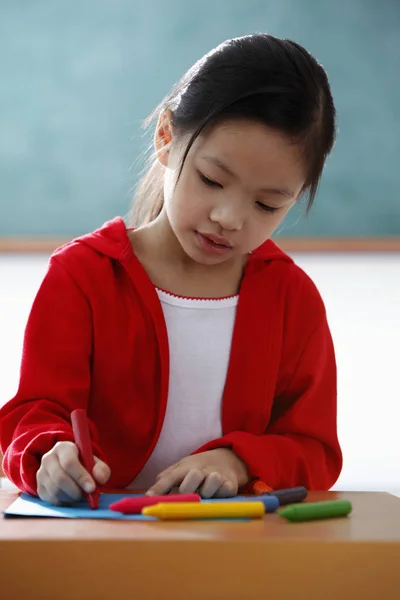 Young girl coloring with crayons — Stock Photo, Image