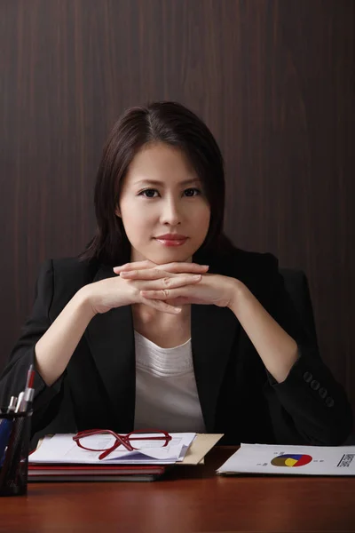 Woman sitting at desk smiling — Stock Photo, Image