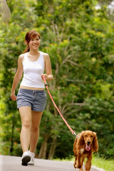 Jonge vrouw lopen haar hond — Stockfoto