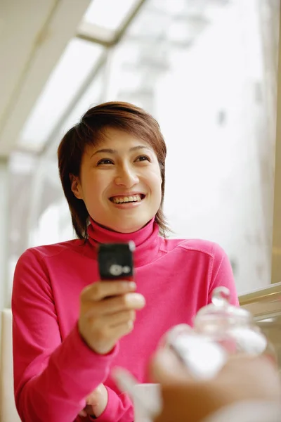 Mujer sosteniendo teléfono móvil — Foto de Stock