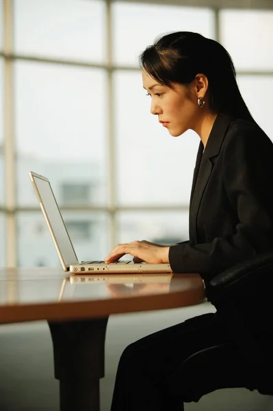 Mujer joven usando el ordenador portátil — Foto de Stock