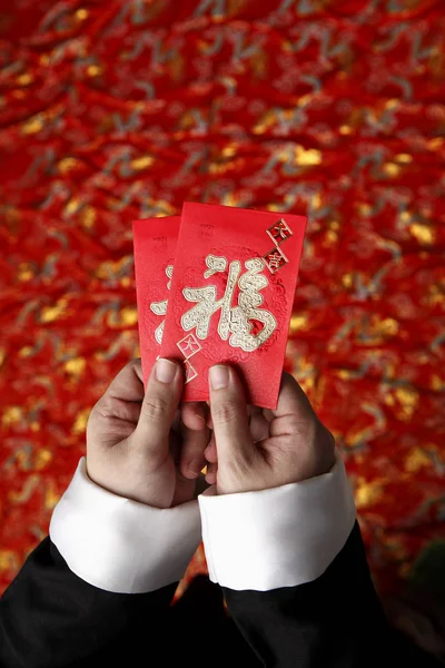 Mãos segurando envelopes vermelhos — Fotografia de Stock